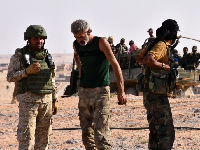 A picture taken on September 6, 2017 shows members of the Syrian government forces in the village of Kobajjep, on the southwestern outskirts of Deir Ezzor, during the ongoing battle against Islamic State (IS) group jihadists.Syria's army and allied fighters, backed by Russian air support, have been advancing towards Deir Ezzor on several fronts in recent weeks, and entered the Brigade 137 base on its western edge, in what Moscow hailed as a key 'strategic victory'. / AFP PHOTO / George OURFALIAN (Photo credit should read GEORGE OURFALIAN/AFP/Getty Images)