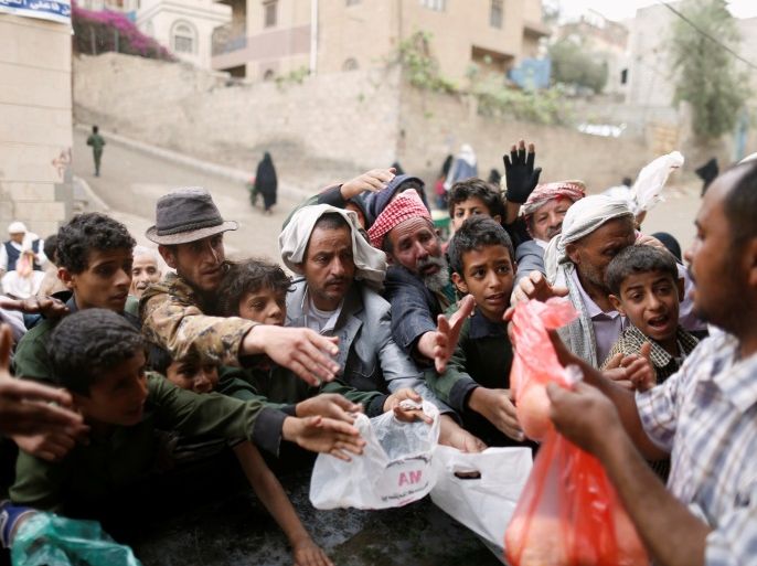 People gather to collect food rations at a food distribution center in Sanaa, Yemen March 21, 2017. REUTERS/Khaled Abdullah