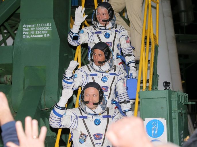 Members of the International Space Station expedition 53/54, NASA astronauts Joseph Acaba (C), Mark Vande Hei (top) and Roscosmos cosmonaut Alexander Misurkin (bottom) wave as they board the Soyuz MS-06 spacecraft prior the launch at the Baikonur cosmodrome, in Kazakhstan, 13 September 2017. REUTERS//Maxim Shipenkov/Pool