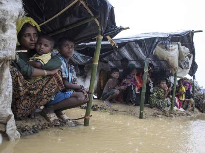 KUTUPALONG, BANGLADESH - SEPTEMBER 17: Refugees shelter from a downpour as the monsoon rains create massive challenges for the displaced Rohingya September 17, 2017 in Kutupalong, Cox's Bazar, Bangladesh. Over 400,000 Rohingya refugees have fled into Bangladesh since late August during the outbreak of violence in the Rakhine state. Recent satellite images released by Amnesty International provided evidence that security forces were trying to push the minority Muslim g