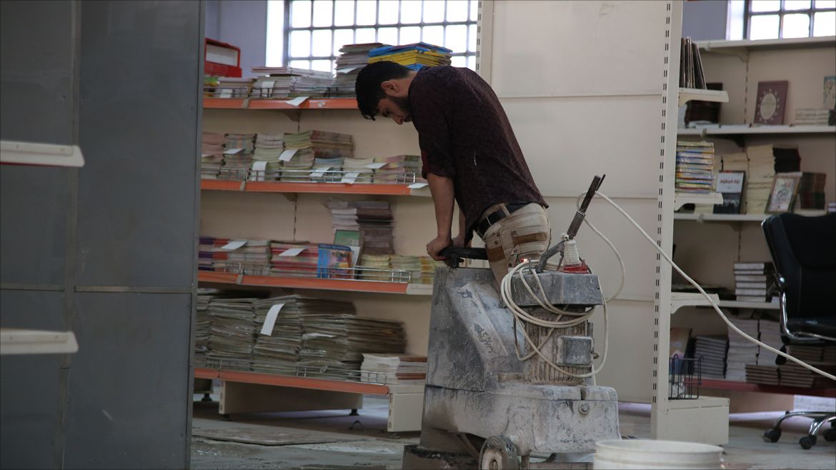 متطوع يقوم بإصلاح أرضية مكتبة مركز البيع المباشر في الجامعة