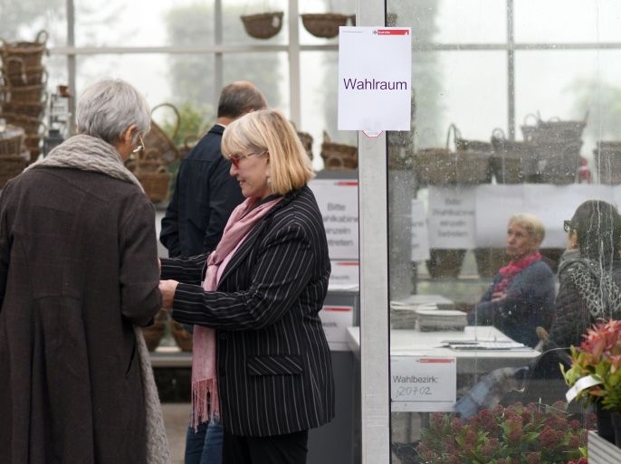 Voters wait to cast their ballots at a polling station installed in a gardening center in Cologne, western Germany, during general elections on September 24, 2017.Polls opened in Germany in a general election expected to hand Chancellor Angela Merkel a fourth term, while the hard-right Alternative for Germany (AfD) party is predicted to win its first seats in the national parliament. / AFP PHOTO / dpa / Henning Kaiser / Germany OUT (Photo credit should read HENNING KAISER/AFP/Getty Images)