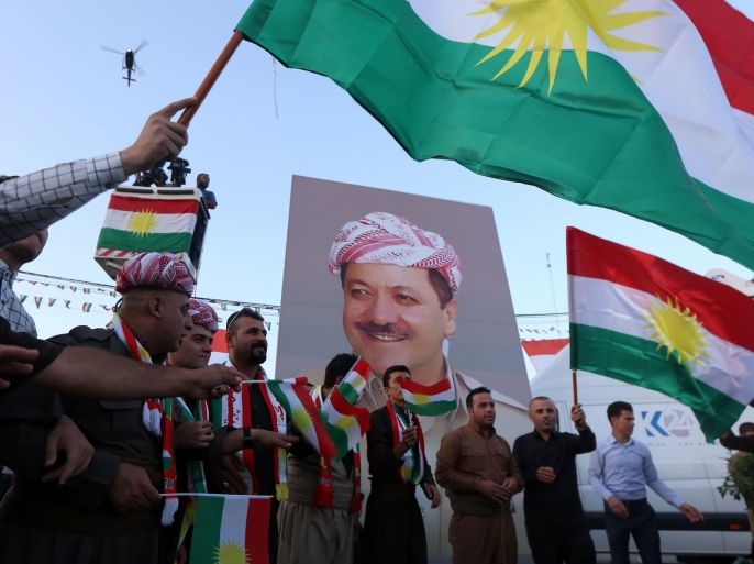 Iraqi Kurds gather in the street waving Kurdish flags next to a poster of the president of Iraq's Kurdistan region as they urge people to vote in the upcoming independence referendum in Arbil, the capital of the autonomous Kurdish region of northern Iraq, on September 13, 2017. Iraq's autonomous Kurdish region will hold a historic referendum on statehood in September 2017, despite opposition to independence from Baghdad and possibly beyond. / AFP PHOTO / SAFIN HAMED (Photo credit should read SAFIN HAMED/AFP/Getty Images)
