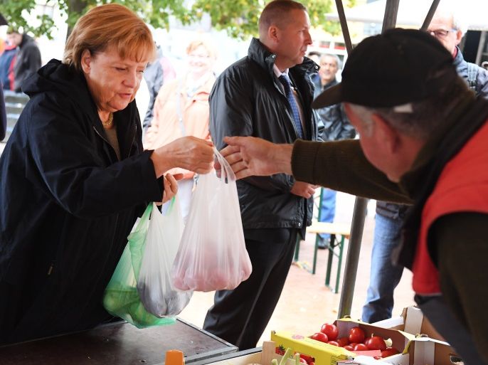German Chancellor Angela Merkel (L), also leader of the Christian Democratic Union (CDU) party, buys some fruit and vegetables at a farmers' market in Barth near Stralsund, northeastern Germany, where she campaigned on September 8, 2017. / AFP PHOTO / dpa / Stefan Sauer / Germany OUT (Photo credit should read STEFAN SAUER/AFP/Getty Images)