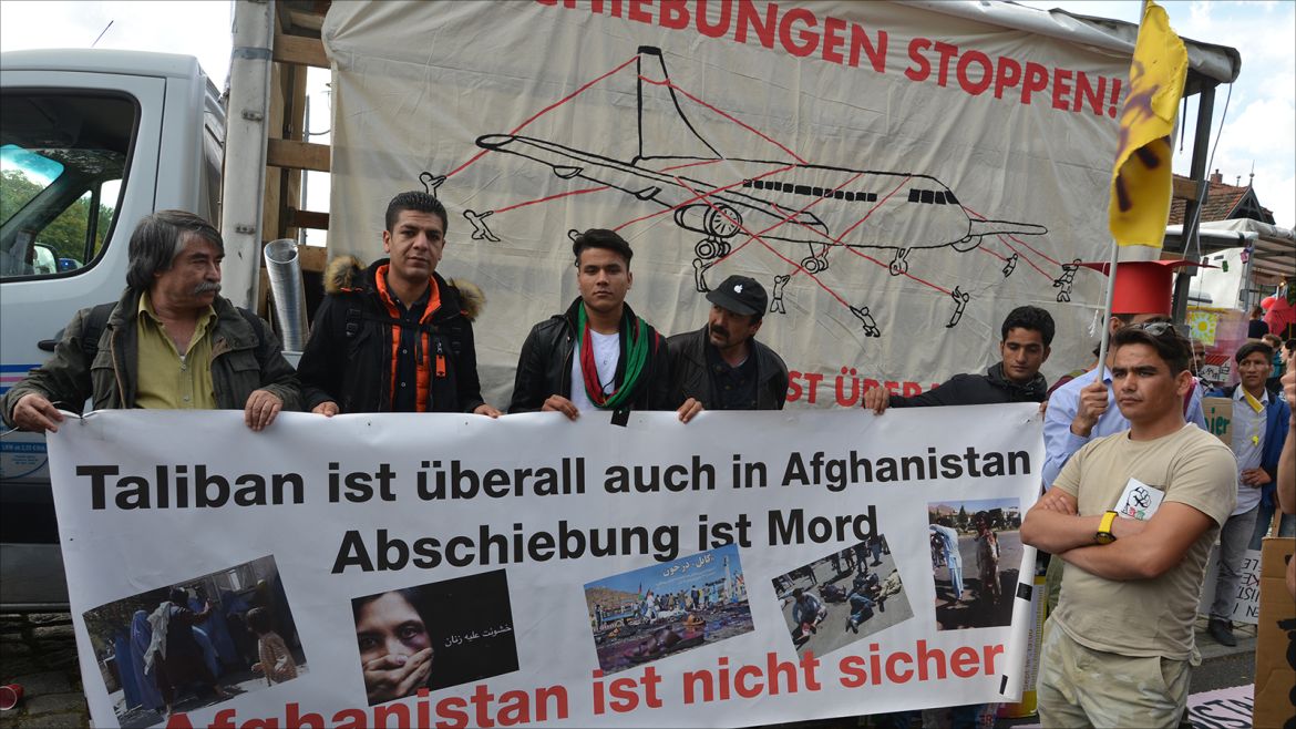 لاجئون أففان يرفعون لافتات عن إضطراب بلدهم.