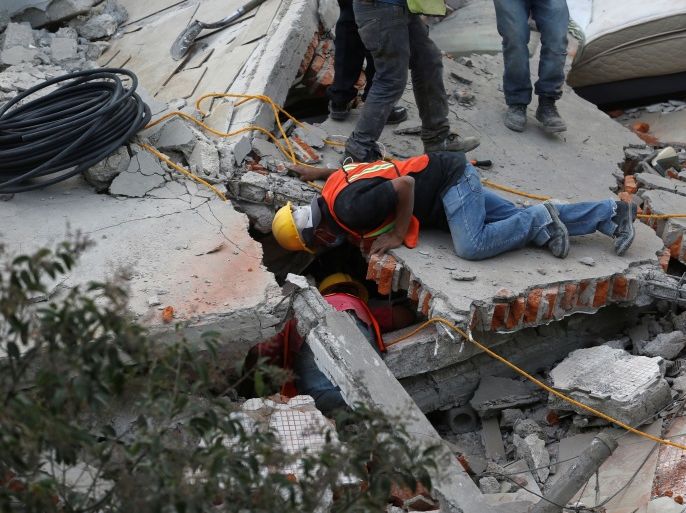Rescue personnel search for people among the rubble of a collapsed building after an earthquake hit Mexico City, Mexico September 19, 2017. REUTERS/Claudia Daut
