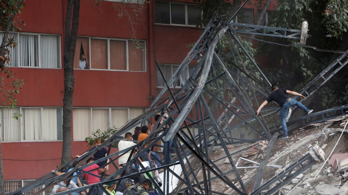People climb over the debris of a collapsed building after an earthquake hit Mexico City, Mexico September 19, 2017. Picture taken September 19, 2017. REUTERS/Ginnette Riquelme