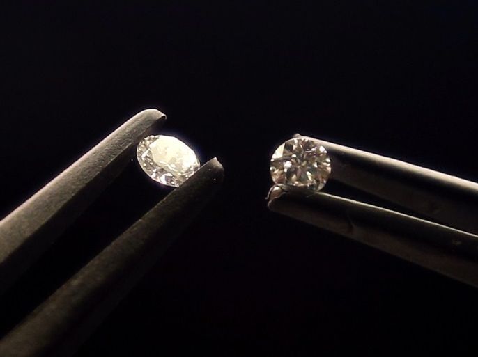 Two diamonds are seen at the HRD Antwerp Institute of Gemmology, December 3, 2012. The right one is a 0.41 carat synthetic diamond and the left one is a slightly larger natural diamond, both visually indistinguishable from each other. HRD Antwerp analyses diamonds with specially designed machinery, as even for experts it is impossible to visually tell the difference between a synthetic stone and a naturally grown one. Picture taken December 3, 2012. REUTERS/Francois Len