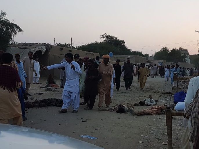EDITORS NOTE: Graphic content / Pakistani devotees gather around the bodies of blast victims after a suicide bombing near a sufi shrine in the Gandawa area of Jhal Magsi district on October 5, 2017.A suicide bomber blew himself up outside a Sufi shrine in Pakistan's restive southwest on October 5, killing 13 people and wounding at least 20 others, officials said. The incident took place in the Jhal Magsi district of the oil and gas rich Balochistan province, bordering