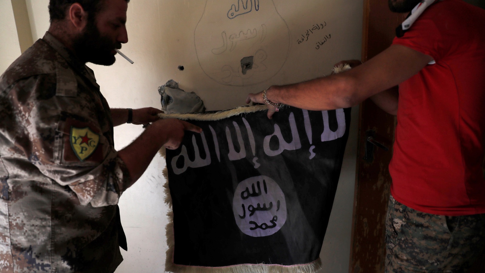 ‪قوات سوريا الديمقراطية بدأت إزالة أعلام وشعارات تنظيم الدولة من مدينة الرقة‬ (رويترز)