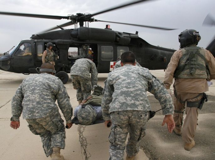 U.S. soldiers rush an injured comrade towards a Medivac Blackhawk helicopter of the Charlie Company 2-227, Aviation Battalion called