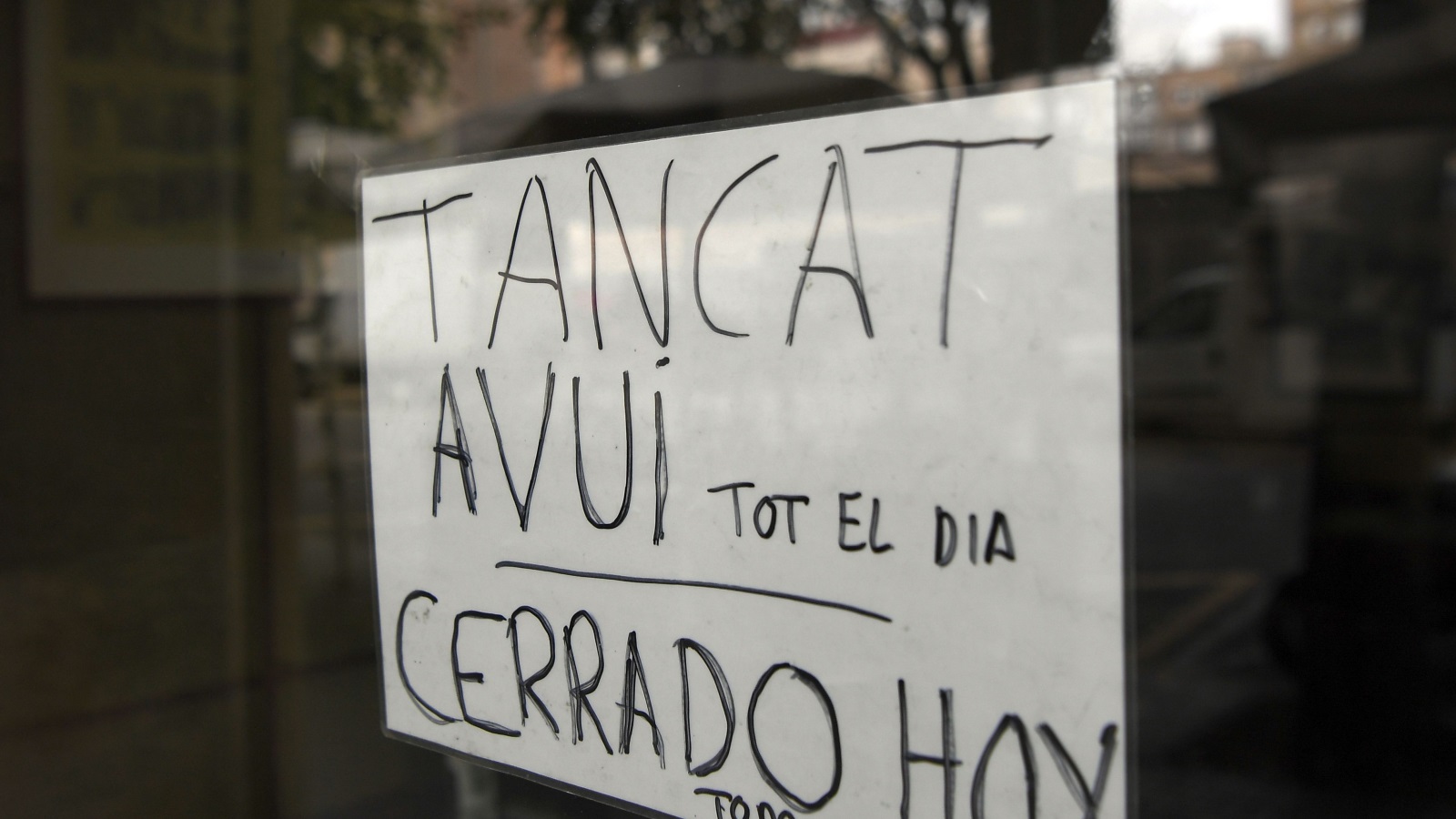 محلات ببرشلونة تعلن باللغتين الكتالونية والإسبانية أنها مغلقة كامل اليوم بسبب الإضراب العام (غيتي)