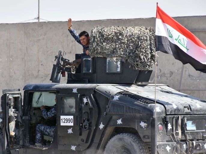 A picture taken on October 20, 2017 shows a fighter loyal to the federal goverment waving from a humvee carrying the Iraqi national flag on a road in the region of Altun Kupri, about 50 kilometres (30 miles) from Arbil, the capital of autonomous Iraqi Kurdistan.Iraqi forces clashed with Kurdish peshmerga fighters on October 20 and retook control of the last sector of the disputed province of Kirkuk, with a general killed in the fighting, security sources said. / AFP PHOTO / Marwan IBRAHIM (Photo credit should read MARWAN IBRAHIM/AFP/Getty Images)
