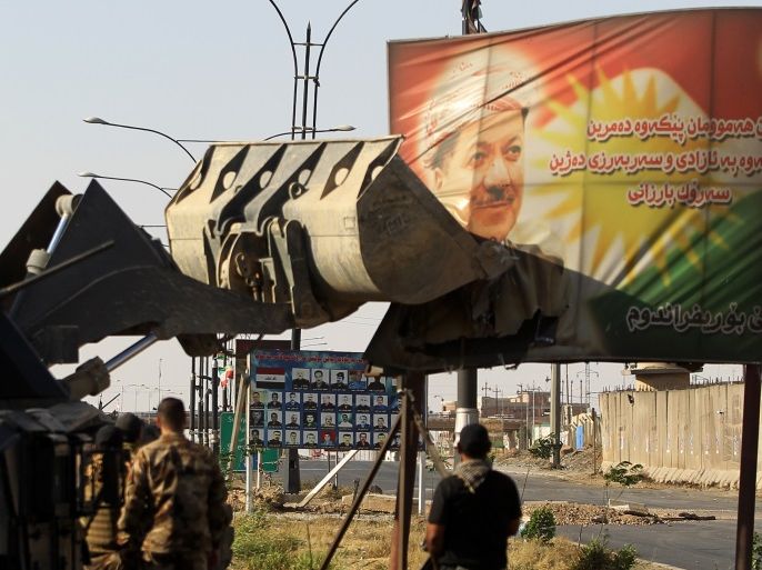Iraqi forces use a tractor to damage a poster of Iraqi Kurdish president Massud Barzani on the southern outskirts of Kirkuk on October 16, 2017. Thousands of residents fled Kurdish districts of Kirkuk for fear of clashes after Iraqi military forces launched operations against Kurdish fighters near the northern city, an AFP journalist said. / AFP PHOTO / AHMAD AL-RUBAYE (Photo credit should read AHMAD AL-RUBAYE/AFP/Getty Images)
