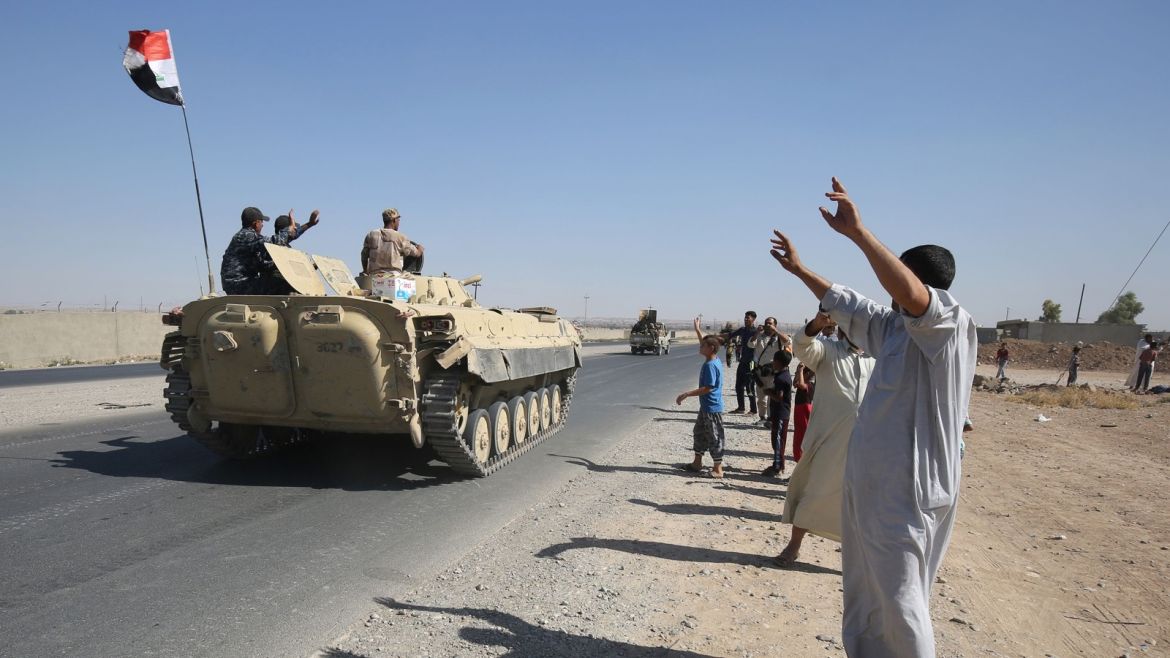 Iraqis wave to Iraqi forces as they arrive in the first neighbourhood on the southern outskirts of Kirkuk on October 16, 2017. Iraqi forces said they had seized an oil field in Kirkuk province during an operation against Kurdish fighters that follows soaring tensions over an independence referendum. / AFP PHOTO / AHMAD AL-RUBAYE        (Photo credit should read AHMAD AL-RUBAYE/AFP/Getty Images)