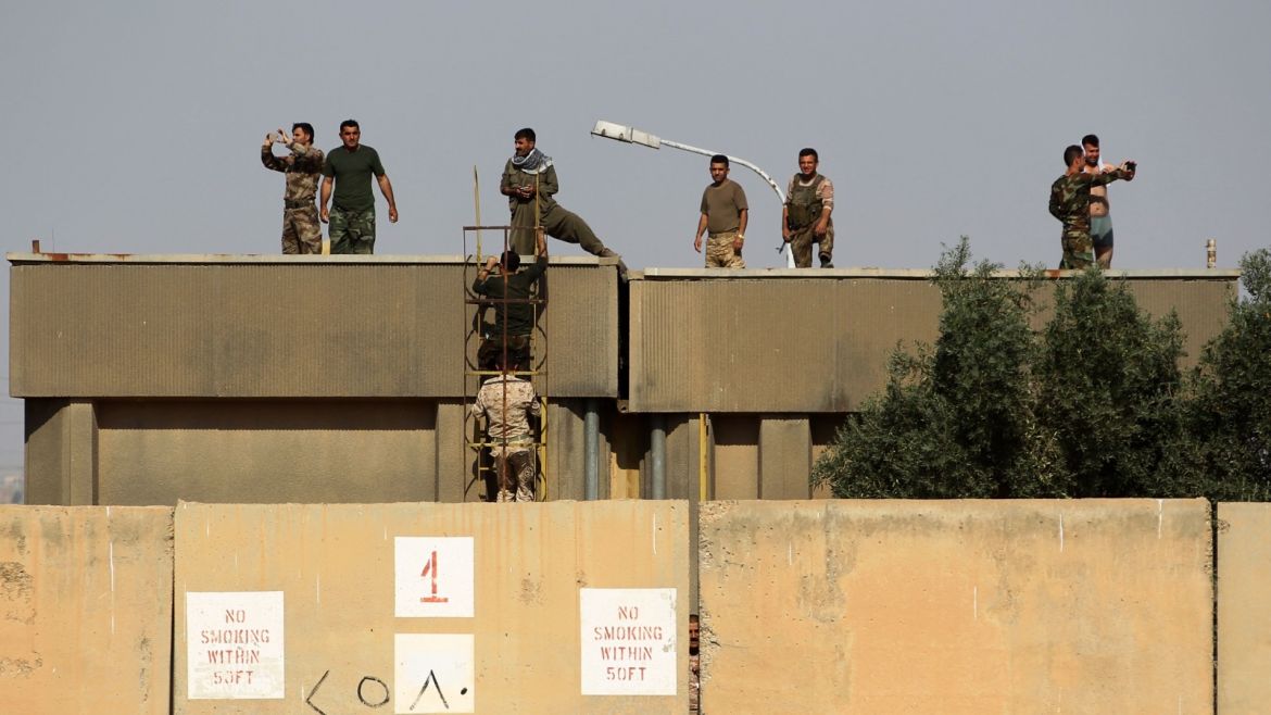Kurdish peshmerga fighters stand on the roof top of a building as they hold a position on the opposition side of river bank from Iraqi forces on the southern outskirts of Kirkuk on October 15, 2017.The presidents of Iraq and Iraqi Kurdistan held talks to defuse an escalating crisis, after a deadline for Kurdish forces to withdraw from disputed positions was extended by 24 hours. / AFP PHOTO / AHMAD AL-RUBAYE        (Photo credit should read AHMAD AL-RUBAYE/AFP/Getty Images)