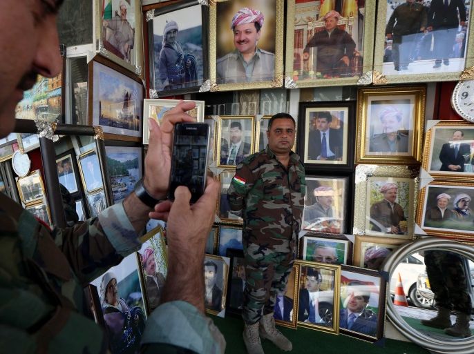 A member of the Iraqi Kurdish peshmerga uses his cell phone to take a posed photograph of a colleague standing alongside portraits of Iraqi Kurdish leader Massud Barzani hanging in a shop in Arbil, the capital of the autonomous Kurdish region of northern Iraq, on August 30, 2017.Iraq's autonomous Kurdish region will hold a historic referendum on statehood in September 2017, despite opposition to independence from Baghdad and possibly beyond. / AFP PHOTO / SAFIN HAMED (Photo credit should read SAFIN HAMED/AFP/Getty Images)