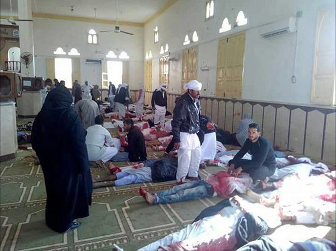 epa06347848 People sit next to bodies of worshippers killed in attack on mosque in the northern city of Arish, Sinai Peninsula, Egypt, 24 November 2017