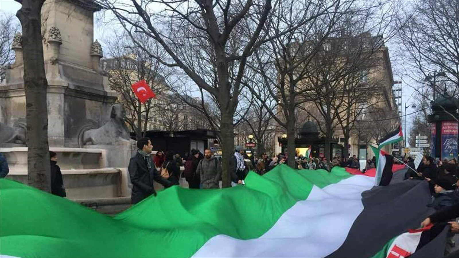 محتجون يرفعون علم فلسطين بمظاهرة باريس الأحد الماضي