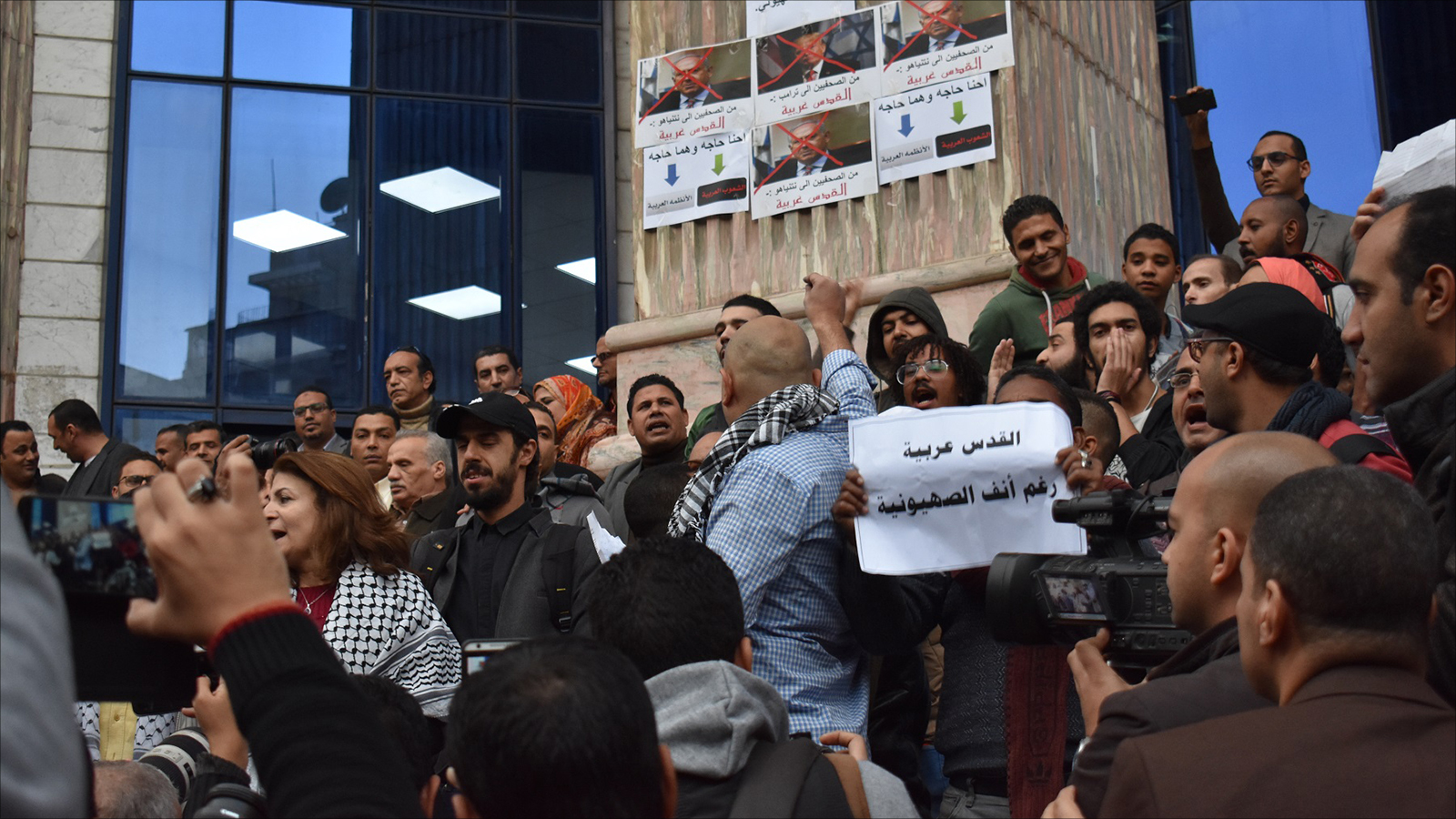 ‪المحتجون يرفعون لافتات مناهضة للصهيونية‬ (الجزيرة)