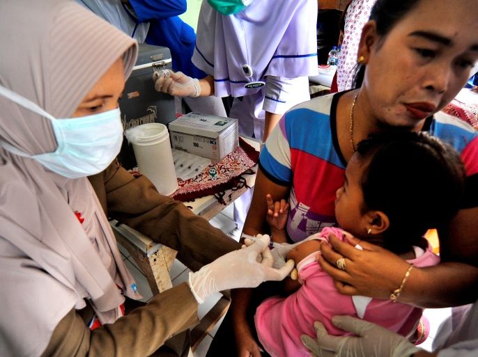 A medical officers vaccinates a child for DPT (Diphtheria, Tetanus and Pertussis or Whooping Cough) in Serang, Banten province, Indonesia December 11, 2017 in this photo taken by Antara Foto. Antara Foto/Fathulrahman/ via REUTERS ATTENTION EDITORS - THIS IMAGE WAS PROVIDED BY A THIRD PARTY. MANDATORY CREDIT. INDONESIA OUT. NO COMMERCIAL OR EDITORIAL SALES IN INDONESIA.