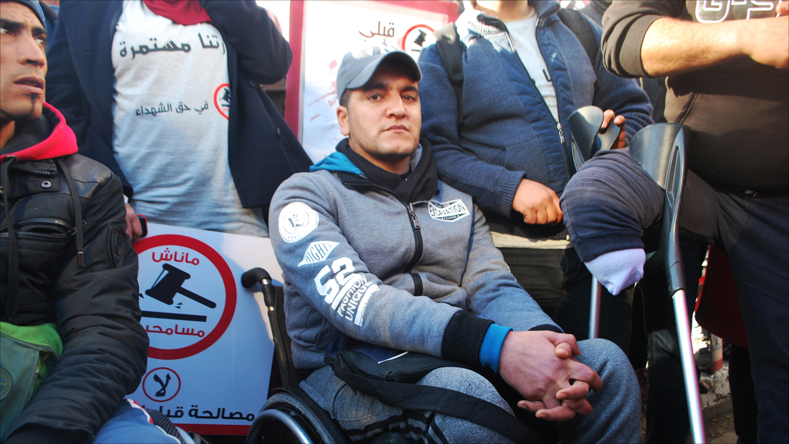 ‪جريح الثورة خالد بن نجمة يشارك في الاحتجاج رغم إعاقته‬ (الجزيرة)