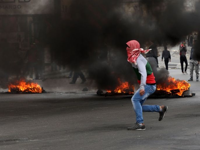 epa06409289 Palestinian protestors throw stones at Israeli troops during clashes at Huwwara checkpoint near the West Bank City of Nablus, 29 December 2017. Clashes erupted as ongoing protests were held against US President Trump's 06 December announcement he is recognizing Jerusalem as the Israel capital and will relocate the US embassy from Tel Aviv to Jerusalem. EPA-EFE/ALAA BADARNEH