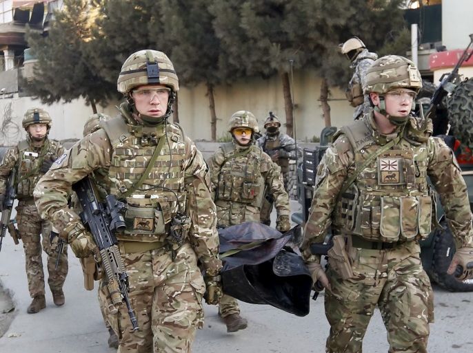 British soldiers carry the dead body of a victim after an attack on a guest house near the Spanish embassy in Kabul, Afghanistan December 12, 2015. Afghan security forces suppressed a suicide attack on a guest house attached to the Spanish embassy in Kabul, killing three Taliban fighters after hours of intermittent gunfire and explosions that lasted into the early hours of Saturday. REUTERS/Mohammad Ismail