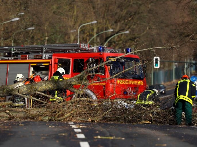 Firefighters work by a fallen tree during stormy weather in Hanau, Germany, January 18, 2018. REUTERS/Kai Pfaffenbach