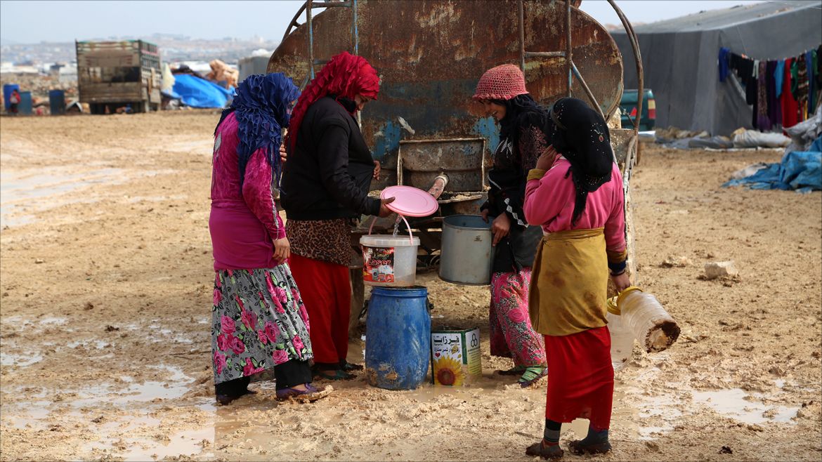 epa06421121 Internally displaced women fill their jerrycans with water at the Kalbeed makeshift camp, near Bab al-Hawa crossing by the Syrian-Turkish border, 06 January 2018. Hundreds of families fled the fighting between government and opposition forces around Idlib.  EPA-EFE/ZEIN ALRIFAII