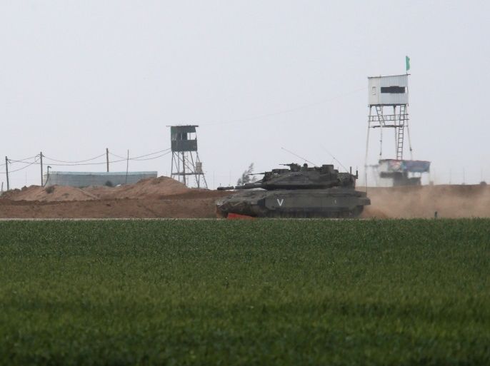 An Israeli tank manoeuvres along the border fence with the southern Gaza Strip, as watch-towers are seen on the Palestinian side near Kibbutz Nirim, Israel February 17, 2018. REUTERS/Amir Cohen