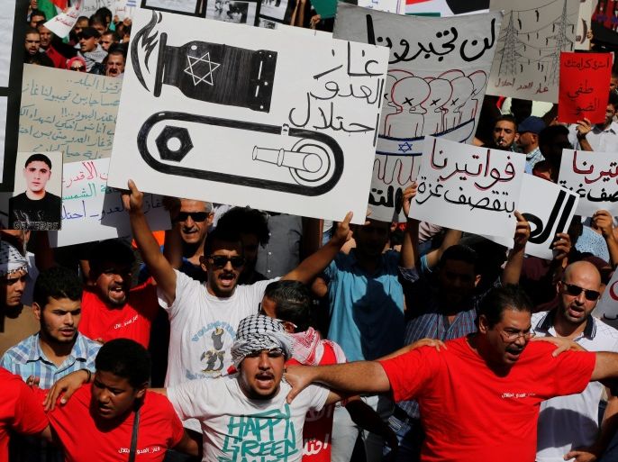 Jordanian protesters chant slogans during a protest against a government agreement to import natural gas from Israel, in Amman, Jordan, October 14, 2016. The center placard reads: