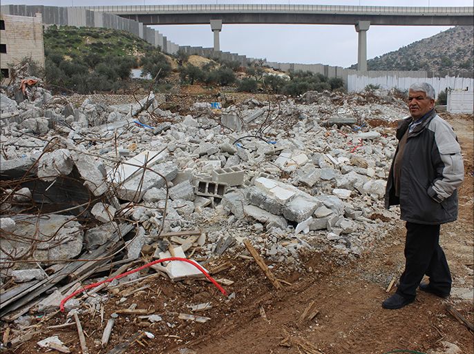 خالد قوار يقف أمام ركام بنايته السكنية التي سوتها جرافات الاحتلال بالأرض