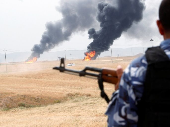 A member of the Kurdish security forces stands guard after explosions at two oil wells in Khabbaz oilfield, 20 km (12 miles) southwest of Kirkuk in Iraq, May 4, 2016. REUTERS/Ako Rasheed