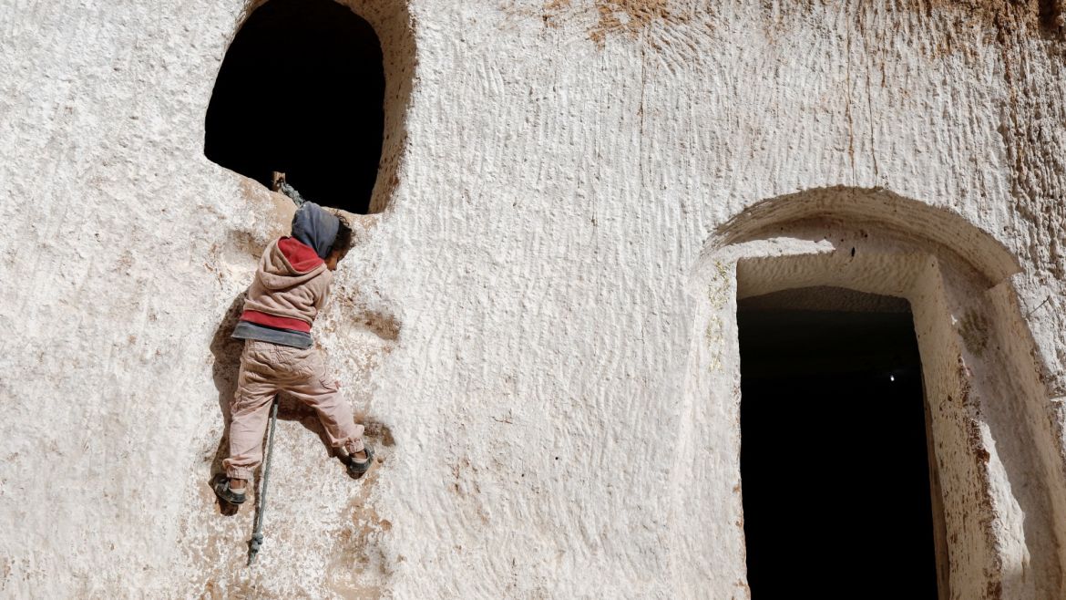 Ahlem, four, climbs up a wall to reach her rabbit's hideaway at her troglodyte house on the outskirts of Matmata, Tunisia, February 5, 2018. REUTERS/Zohra Bensemra  SEARCH