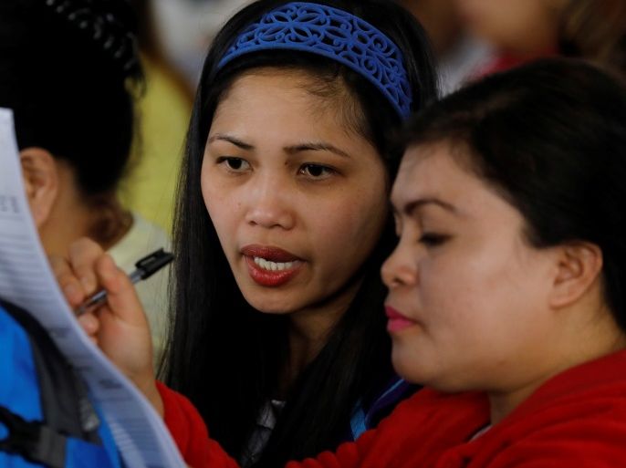 Filipino workers who were repatriated from Kuwait fill out labour-related papers upon arrival at Ninoy Aquino International Airport in Paranaque, Metro Manila, Philippines February 12, 2018. REUTERS/Erik De Castro