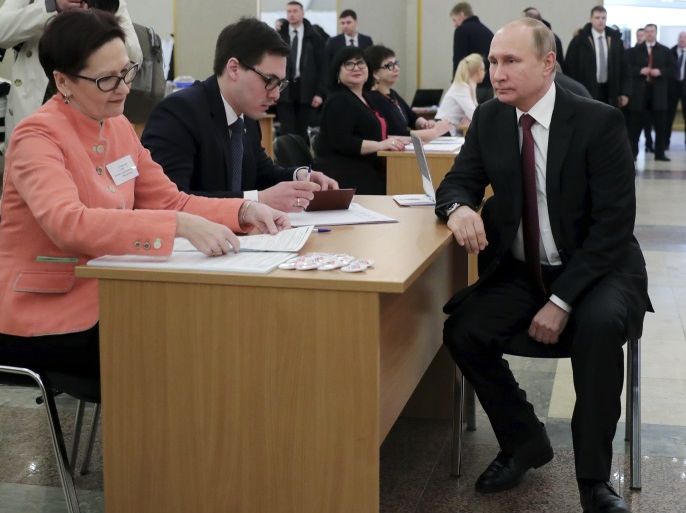 Russian President and presidential candidate Vladimir Putin waits before receiving his ballot at a polling station during the election in Moscow, Russia March 18, 2018. Sputnik/Mikhail Klimentyev/Kremlin via REUTERS ATTENTION EDITORS - THIS IMAGE WAS PROVIDED BY A THIRD PARTY.