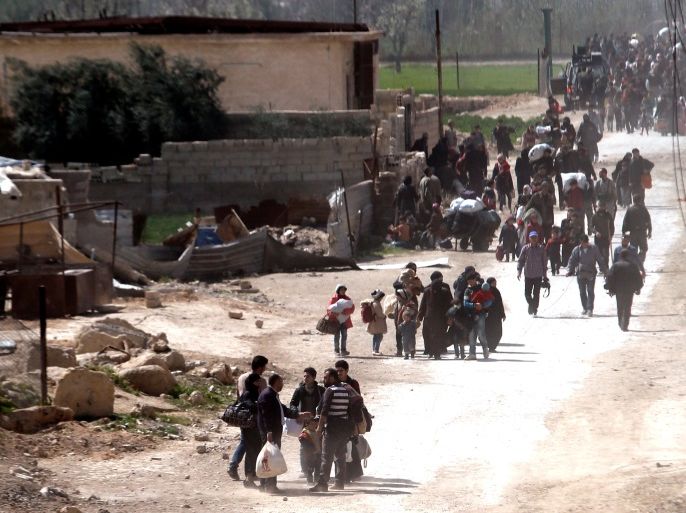 People walk with their belongings as they flee the rebel-held town of Hammouriyeh, in the village of Beit Sawa, eastern Ghouta, Syria March 15, 2018. REUTERS/Omar Sanadiki