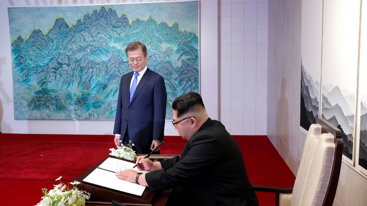 South Korean President Moon Jae-in watches as North Korean leader Kim Jong Un writes in a guestbook at the Peace House at the truce village of Panmunjom inside the demilitarized zone separating the two Koreas, South Korea, April 27, 2018.   Korea Summit Press Pool/Pool via Reuters