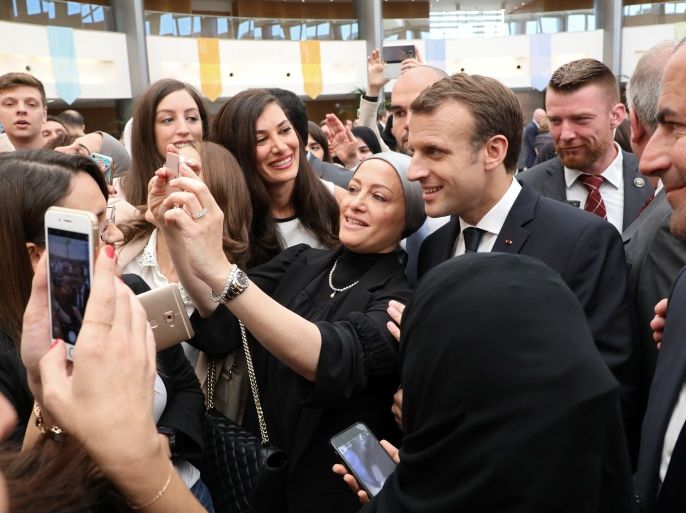 French President Emmanuel Macron poses for a selfie as he stands with students during his visit the Paris-Sorbonne University Abu Dhabi, UAE, November 9, 2017. REUTERS/Ludovic Marin/Pool