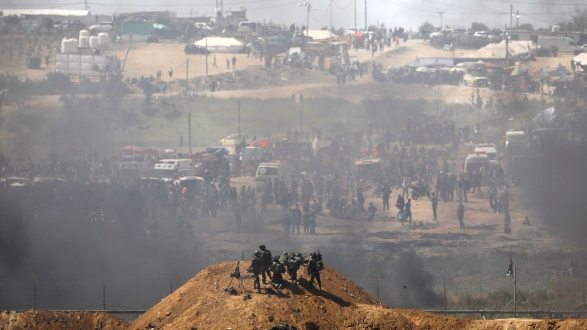 Israeli soldiers are seen next to the border fence on the Israeli side of the Israel-Gaza border as Palestinians protest on the Gaza side of the border April 6, 2018. REUTERS/Amir Cohen     TPX IMAGES OF THE DAY