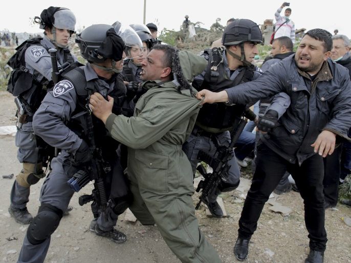 A Palestinian man scuffles with Israeli border policemen as they clear a protest on land that Palestinians said was confiscated by Israel for Jewish settlements, near the West Bank town of Abu Dis near Jerusalem February 16, 2015. REUTERS/Ammar Awad (WEST BANK - Tags: POLITICS CIVIL UNREST TPX IMAGES OF THE DAY)