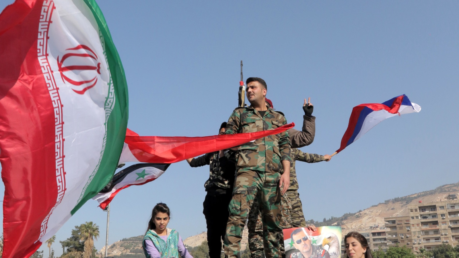 ‪جنود سوريون يحملون الأعلام الروسية والإيرانية‬ جنود سوريون يحملون الأعلام الروسية والإيرانية (الأوروبية)