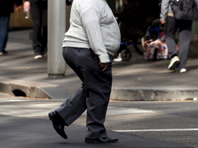 A man crosses a main road as pedestrians carrying food walk along the footpath in central Sydney, Australia, August 12, 2015. Fast food may be falling out of favour in many countries around the world but companies are making healthy profits and boldly innovating in the unlikely market of Australia. Contrary to stereotypes of a beach-going community of fitness fanatics, official data out this week showed 40 percent of Australian adults are dangerously obese and have a po