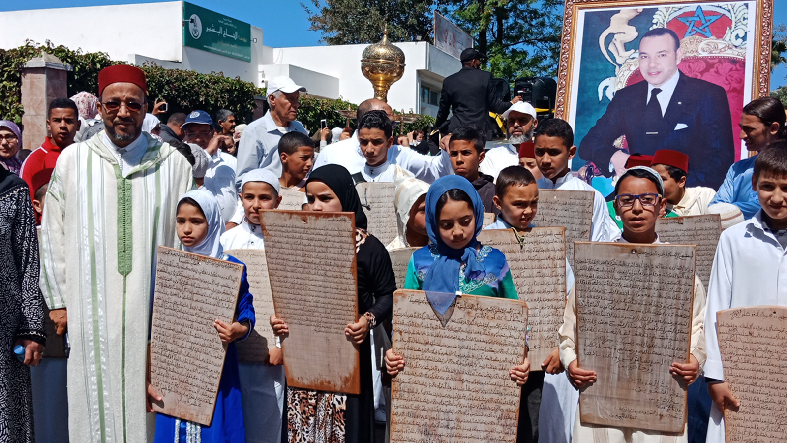 ‪يتقدم المسيرة أطفال يحملون ألواحا خشبية مكتوبا عليها آيات بينات من الذكر الحكيم‬ (الجزيرة)