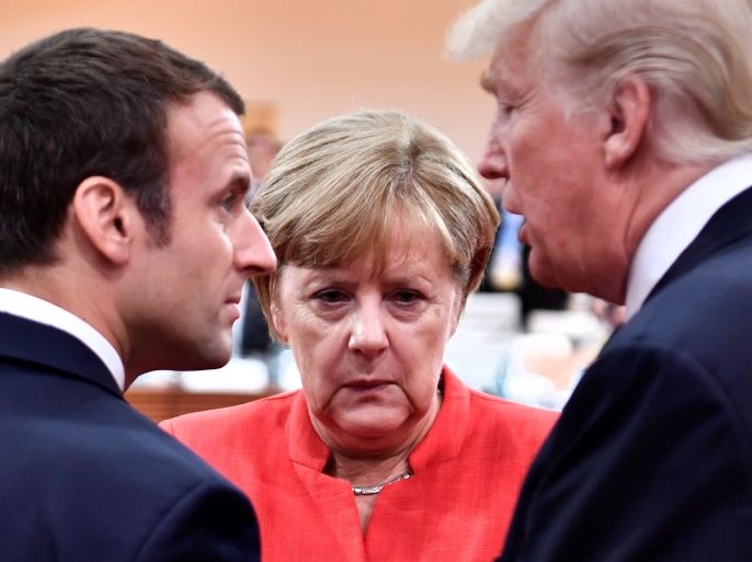 French President Emmanuel Macron, German Chancellor Angela Merkel and U.S. President Donald Trump confer at the start of the first working session of the G20 meeting in Hamburg, Germany, July 7, 2017. REUTERS/John MacDougall/Pool