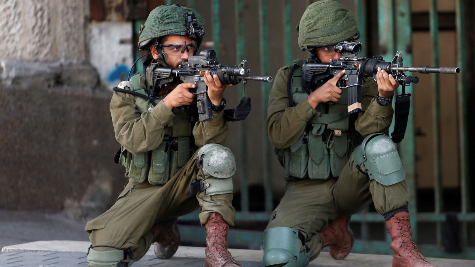 جنود الاحتلال يوجهون بنادقهم نحو المحتجين الفلسطينيين في الخليل (رويترز)
