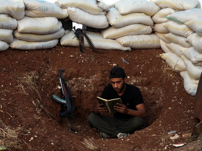 A Free Syrian Army fighter reads the Quran in the rebel-held town of Dael, Syria May 30, 2018. REUTERS/Alaa Al-Faqir
