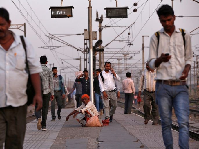 Passengers walk on a platform as others wait to board their trains at Ghaziabad railway station on the outskirts of New Delhi, India, April 20, 2017. Picture taken April 20, 2017. REUTERS/Adnan Abidi