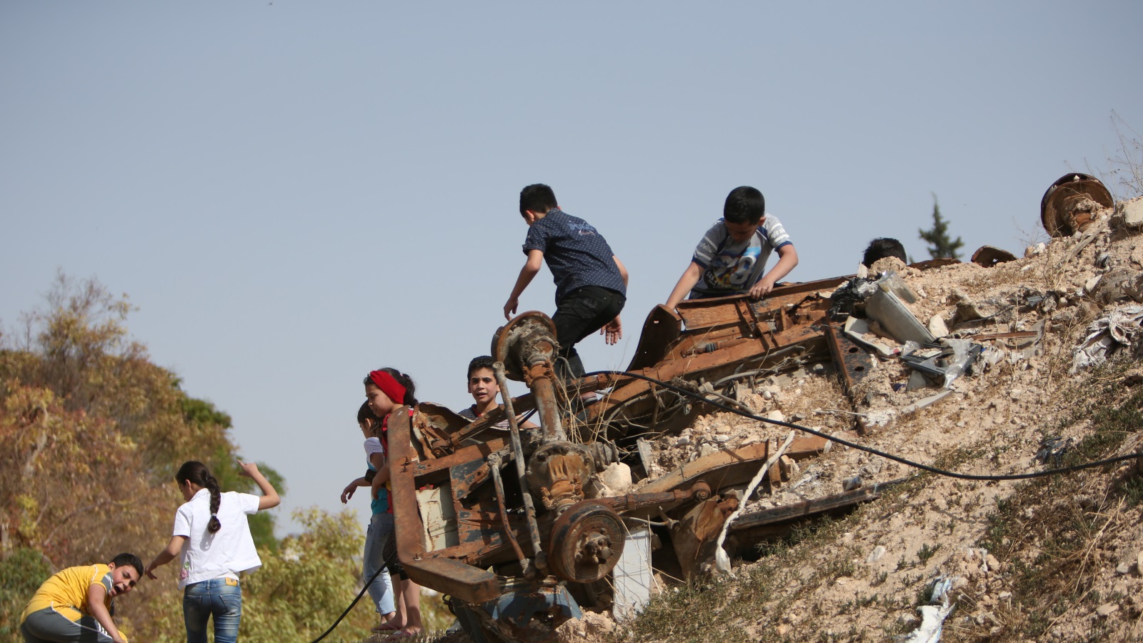 أطفال الغوطة يلهون فوق إحدى الشاحنات المدمرة في الحرب 